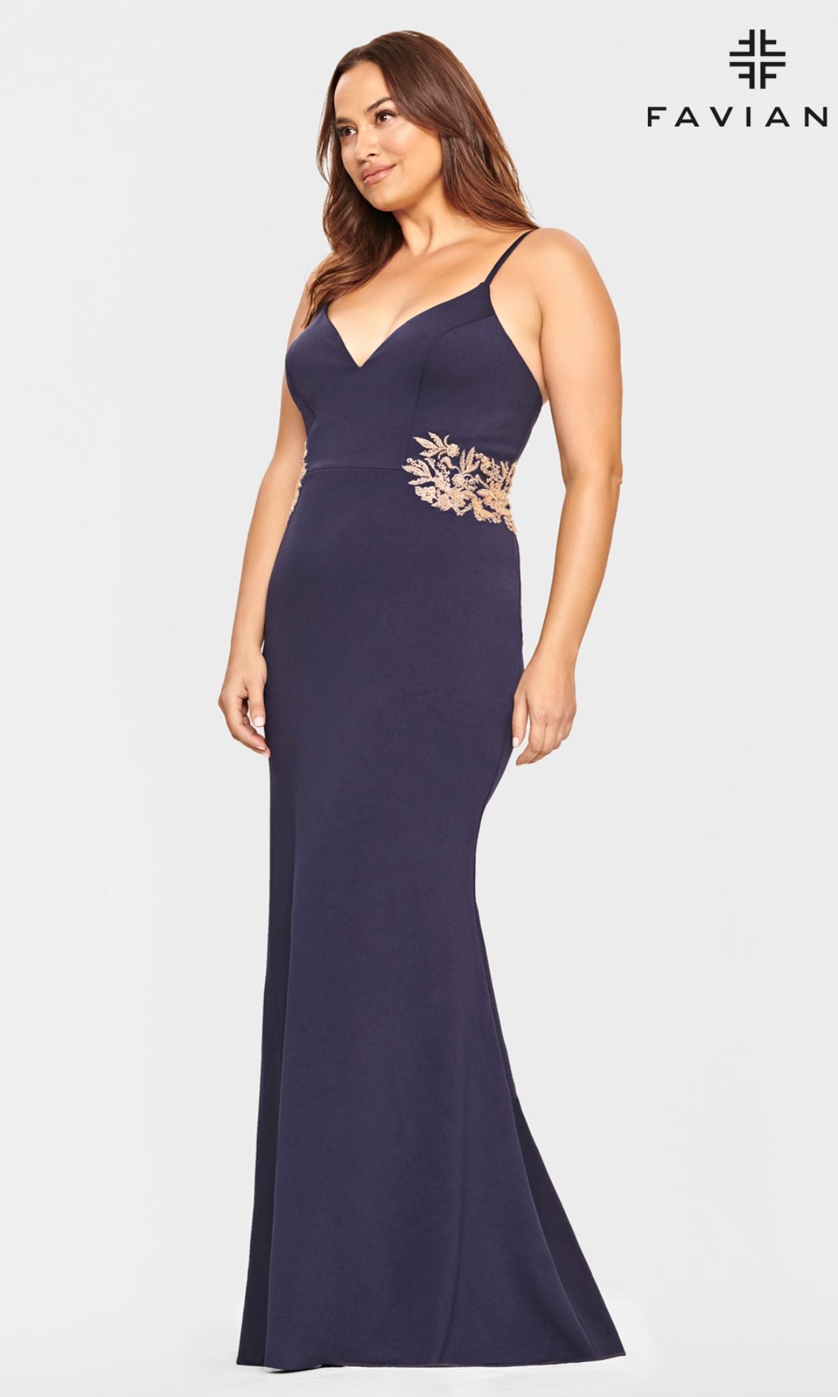 A woman models the Navy and Gold Plus-Size Faviana Prom Dress 9540, featuring gold waist embroidery, against a plain background with the Faviana logo in the top right corner.